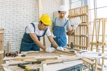 Carpenter using hammer, glue and wooden dowel. Close up view