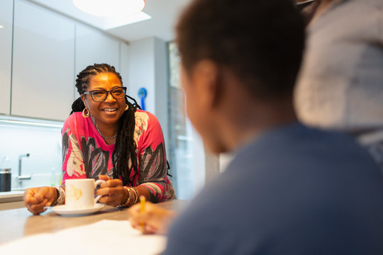 Smiling grandmother talking to grandson in kitchen