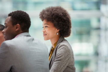 Smiling, confident businesswoman listening in meeting