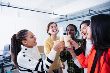 Happy businesswomen celebrating, drinking champagne