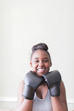 Portrait confident teenage girl wearing boxing gloves