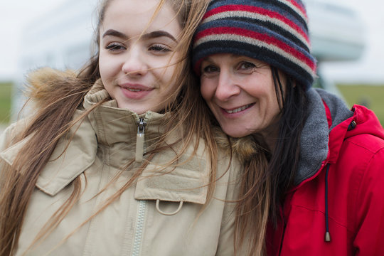 Smiling, affectionate mother and daughter in warm clothing