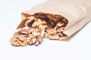 Walnuts sprinkled in paper bags spilled out onto a white kitchen table