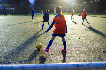 Girls soccer team practicing on field at night