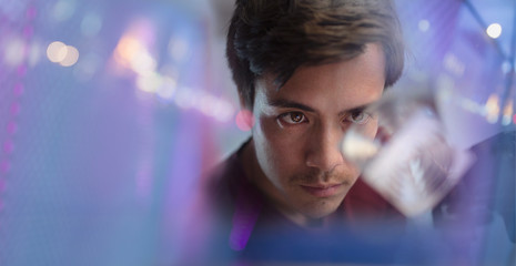 Focused male innovator examining prototype