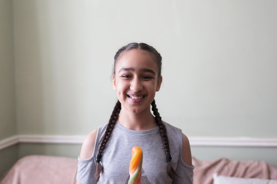 Portrait smiling, confident tween girl eating flavored ice