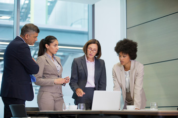 Business people working at laptop in conference room meeting