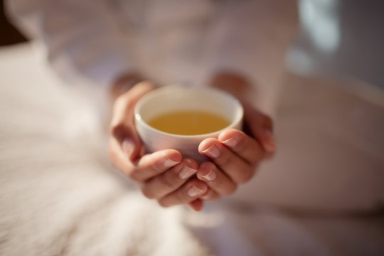 Close Up Woman Cupping Hot Tea