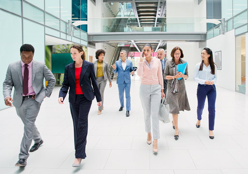 Business people walking in modern office atrium lobby