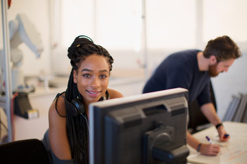Portrait confident female engineer working at computer in office