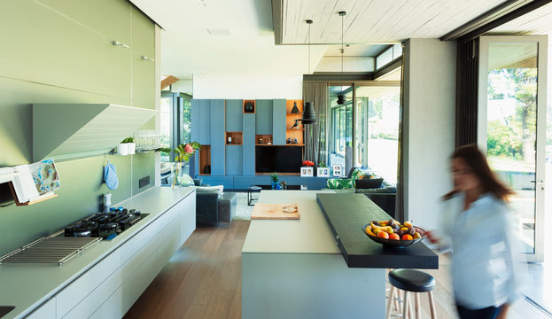 Woman walking in modern, luxury kitchen