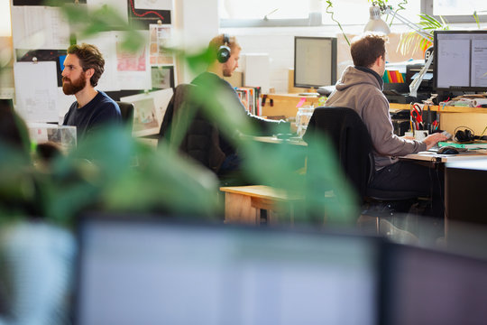 Creative business people working at computers in open plan office