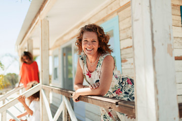 Portrait smiling, confident woman on sunny beach hut patio