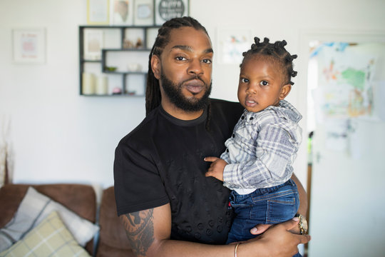 Portrait confident father holding toddler son