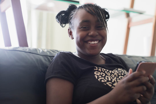 Portrait smiling, confident tween girl texting with smart phone
