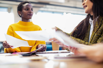 Businesswomen discussing paperwork in meeting