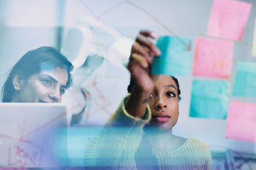 Businesswomen with adhesive notes planning in office