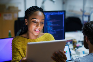 Female computer programmer using digital tablet in office