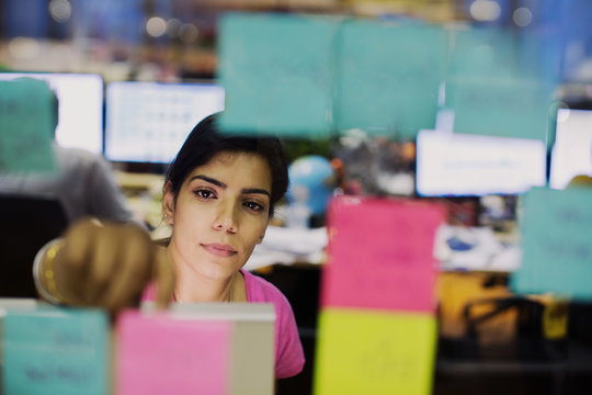 Dedicated businesswoman with adhesive notes planning in office
