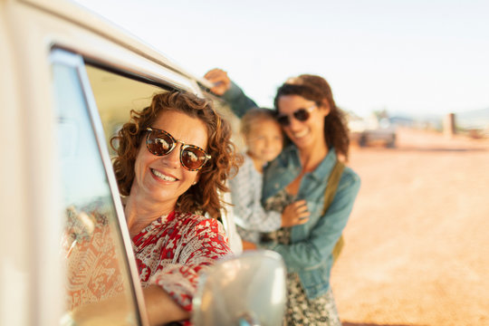 Portrait happy multi-generation women at van on sunny beach