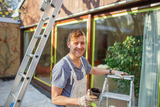 Portrait Confident Male Painter With Ladder Painting Home Exterior