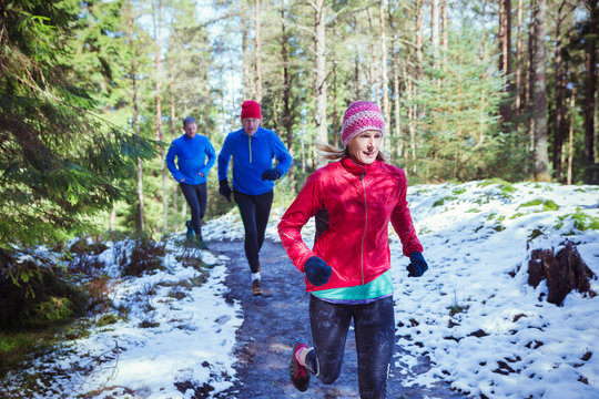 Family jogging in snowy woods