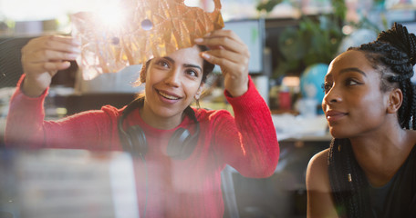 Female engineers examining prototype in office
