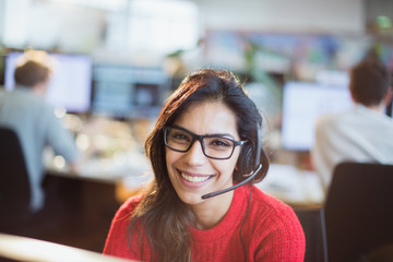 Portrait confident, smiling businesswoman with headset working in office