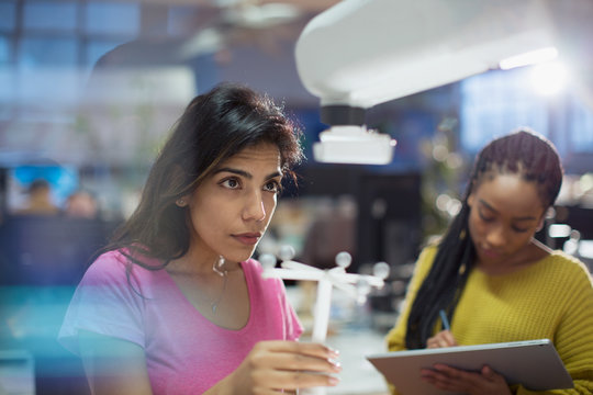 Female engineers testing robotic arm in office