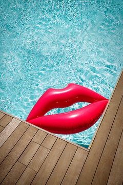 Inflatable lips in corner of sunny summer swimming pool