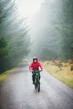 Man mountain biking in rain