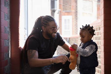 Father and toddler son playing with stuffed animal