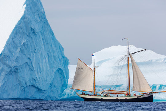 Ship sailing along majestic icebergs on Atlantic Ocean Greenland