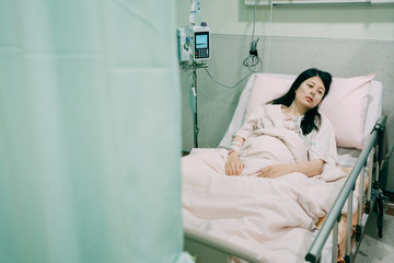Depressed young asian korean woman patient does not believe that she will recover. illness lady in hospital room lying in bed looks pensive thoughtful. lonely girl wear nose tube to keep breathing.