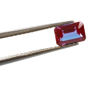 Tweezers holding alexandrite gemstone