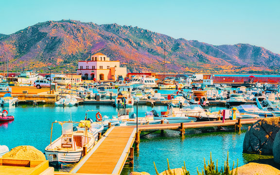 Old Sardinian Port and marina with ships at Mediterranean Sea in city of Villasimius in South Sardinia Island Italy in summer. Cityscape with Yachts and boats