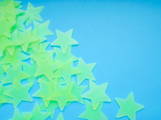 green stars on a blue background. stars glowing in the dark, place for text - obrazy, fototapety, plakaty