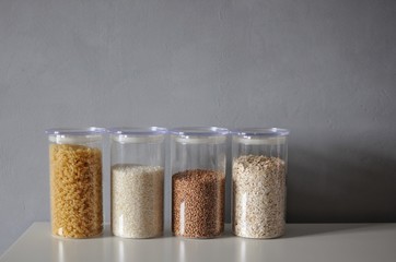  Variety uncooked cereals for healthy cooking in a glass jars on grey background