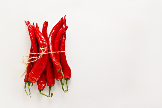 Red chili peppers on light gray wood background. Hot spicy food ingredient