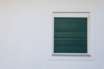 Obraz na płótnie Canvas White plastic window with green shutters.