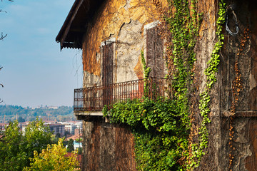 Mysterious stylish italian abandoned house with ivy. Beautiful view from the hill. Bergamo city. Italy.
