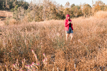 The girl is traveling in the grass field cockscomb grass.