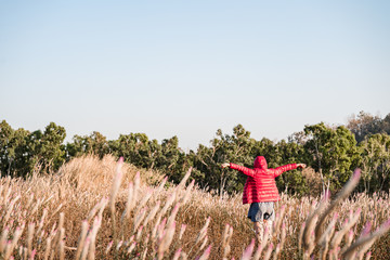 The girl is traveling in the grass field cockscomb grass.