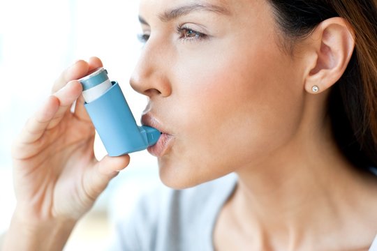 Young woman using inhaler