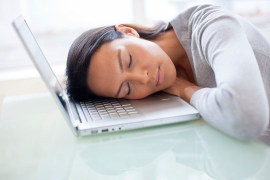 Young woman asleep on laptop