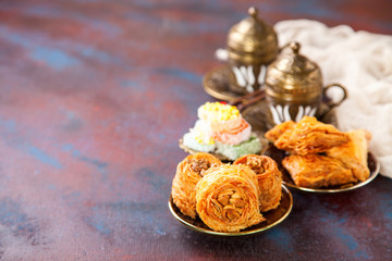 Fototapeta na wymiar Traditional arabic desserts Kunafa and Baklava with honey and nuts. Selective focus. Copy space.
