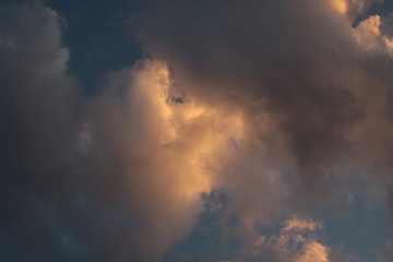 beautiful section of cloud filled sky at golden hour showing blue, grey, gold, yellow and orange hues at sunset during Australian summer