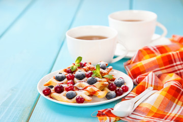 Homemade wafers with berries and tea on a table. Selective focus. Copy space.