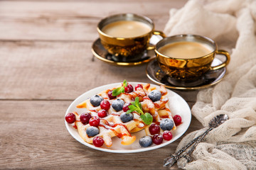Homemade wafers with berries and coffee on a table. Selective focus. Copy space.