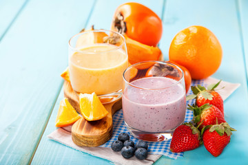 Orange persimmon blueberry smoothie with granola  and fruits. Selective focus. Copy space